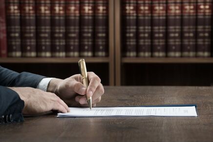 Image of attorney in conference room signing application for mid-range case portfolio loan from Advanced Legal Capital